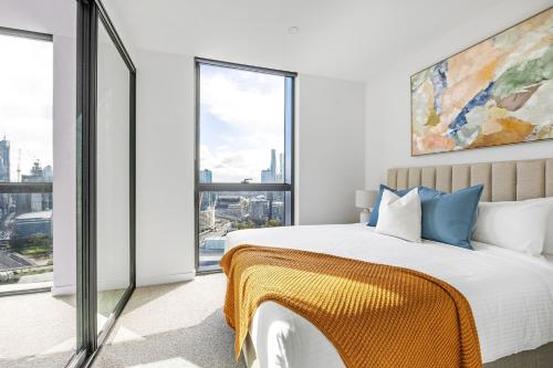 a bedroom with a bed and a large window at Urban Rest Southbank in Melbourne