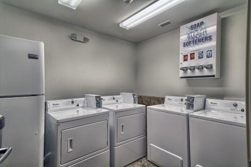 eine Waschküche mit drei Waschmaschinen und einem Kühlschrank in der Unterkunft Motel 6-Weslaco, TX in Weslaco