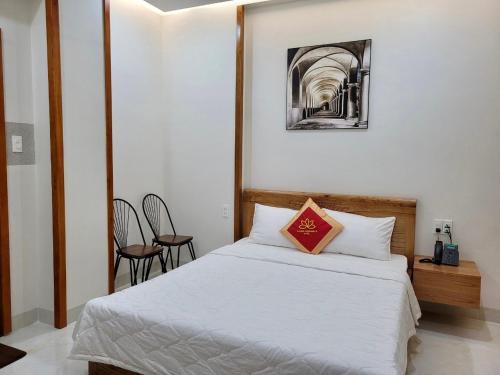 a bedroom with a bed and a table and chairs at Khách Sạn Bảo Hoàng Vũng Tàu in Vung Tau