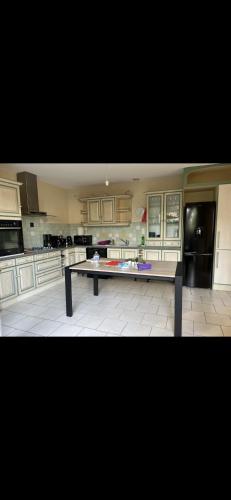 une grande cuisine avec une table au milieu dans l'établissement Maison familiale à Domino, à Saint-Georges-dʼOléron