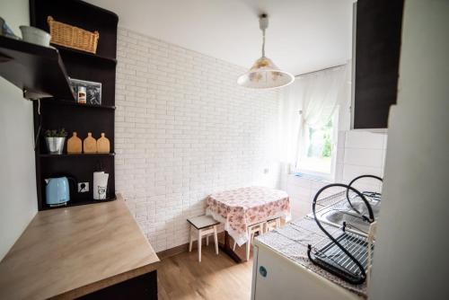 a kitchen with a white brick wall and a table at Myśliwski in Jagodne Wielkie