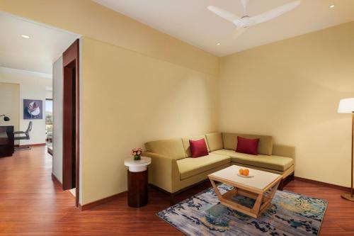 a living room with a couch and a table at Ramada Encore by Wyndham Udaipur Roopnagar in Udaipur