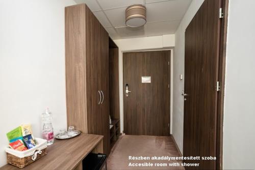 a room with a wooden table and a door at Hotel Írisz in Nyíregyháza