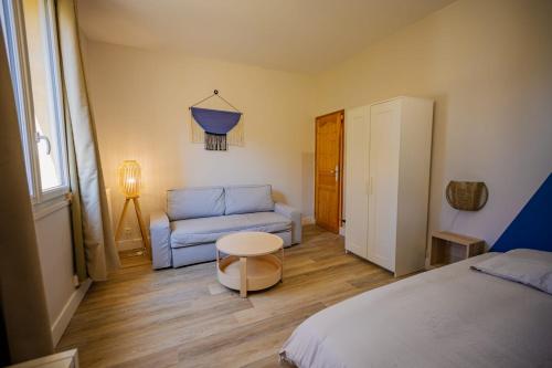 une chambre avec un lit, un canapé et une table dans l'établissement Le Nid Secret 5 Minutes a pied de la plage avec place Parking privée, au Havre