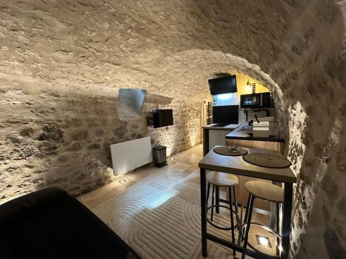 une pièce avec une cuisine et un comptoir dans une grotte dans l'établissement La Cave du Port - CDDT, à La Rochelle
