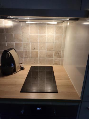 une pièce avec un bureau avec un téléphone et un mur carrelé dans l'établissement Naturistecapdagde Héliopolis avec garage Katrina, au Cap d'Agde