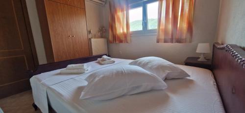 a bedroom with a white bed with towels on it at Makis Nest Apart-Hotel in Vourvourou