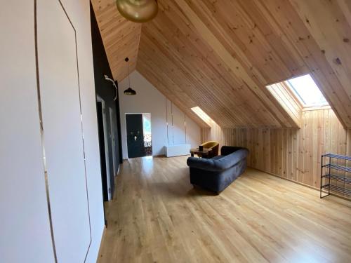 a living room with a blue couch in a room with wooden walls at Ostoja Skarlin in Mikołajki Pomorskie