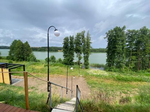 a path leading to a lake with a street light at Ostoja Skarlin in Mikołajki Pomorskie