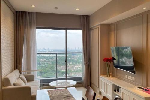 a living room with a large window with a view at Lovely 2 BR Apartment at Branz BSD in Samporo