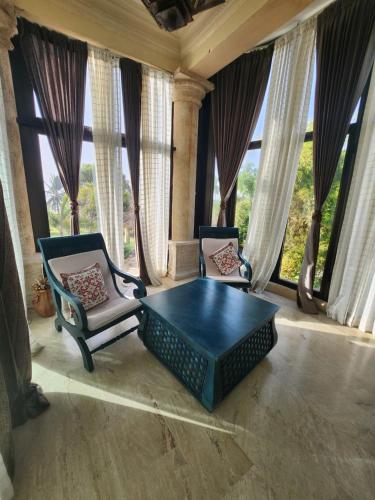 a living room with two chairs and a table at Villa Tesoros del Mar - Luxury Beachfront Villa with Natural Pool, Jacuzzi, Mountain Views, Yoga, BBQ, Wi-Fi, Pet & Family Friendly, Barahona Adventures in El Arroyo