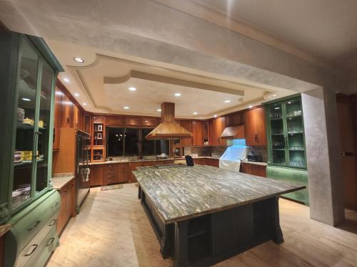 a large kitchen with a large stone counter top at Villa Tesoros del Mar - Luxury Beachfront Villa with Natural Pool, Jacuzzi, Mountain Views, Yoga, BBQ, Wi-Fi, Pet & Family Friendly, Barahona Adventures in El Arroyo