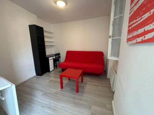 un canapé rouge et un tabouret rouge dans une pièce dans l'établissement Charmant studio Carmes 4 - CDDT, à La Rochelle