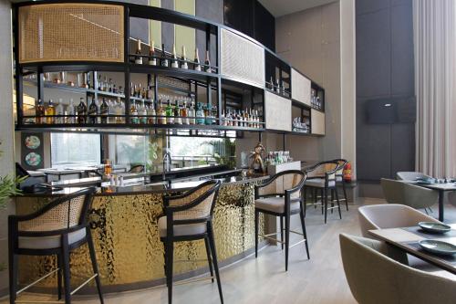 a bar in a restaurant with chairs and tables at Mercure Chandigarh Tribune Chowk in Chandīgarh