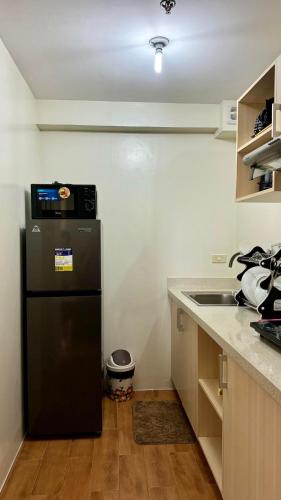 a kitchen with a black refrigerator and a sink at Seawind Condominium Sasa, Davao City in Davao City