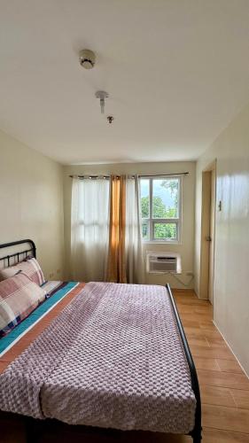 a bedroom with a large bed and a window at Seawind Condominium Sasa, Davao City in Davao City
