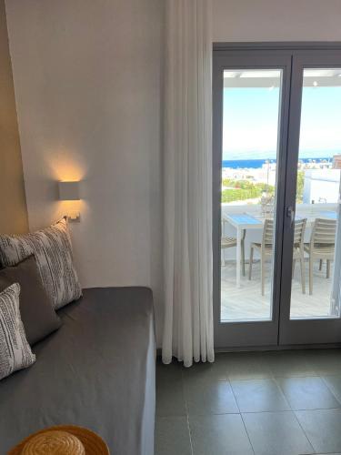 a living room with a couch and a sliding glass door at CAELI PAROS by Kostas & Joanna Studios in Logaras