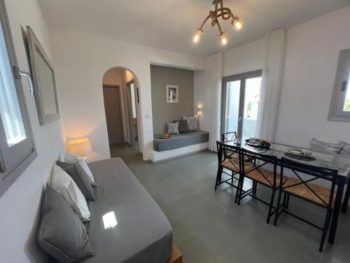 a living room with a bed and a table in it at CAELI PAROS by Kostas & Joanna Studios in Logaras