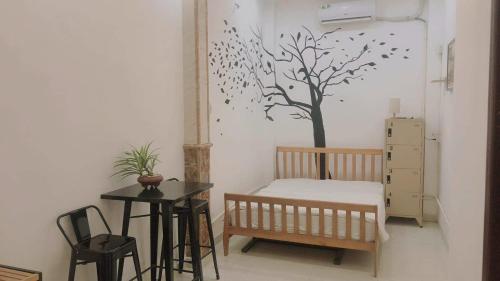 ein Schlafzimmer mit einem Bett und einem Baumwandbild an der Wand in der Unterkunft Alleyway home in Ho-Chi-Minh-Stadt