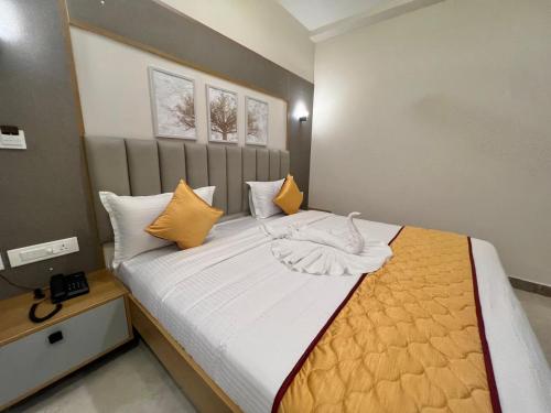 a bedroom with a large bed with orange and white pillows at Hotel Sunlight in Puducherry