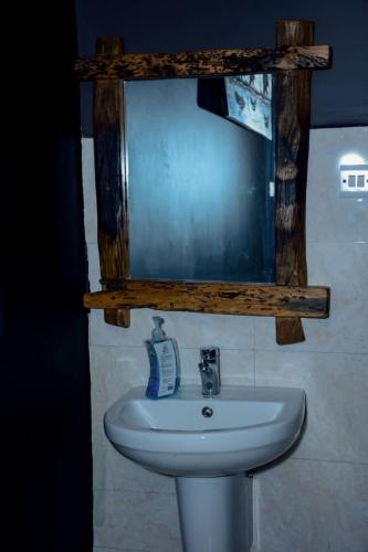a bathroom with a white sink and a mirror at Love House in Dodoma