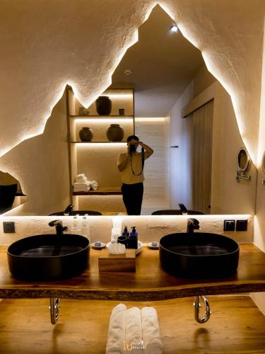 a woman taking a picture of a bathroom with two sinks at Z9 Resort in Si Sawat
