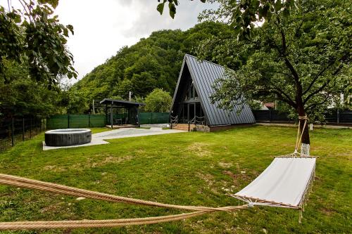 a tent in a yard with a tree at Roman A Frame Vișeu de Sus in Vişeu de Sus
