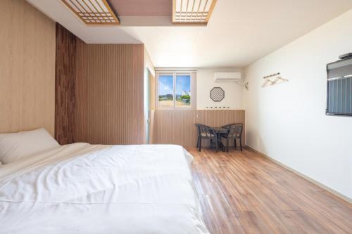 a bedroom with a bed and a table in it at Gyeongju Hotel Check-in Bulguk in Gyeongju