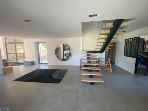 a living room with a staircase and a mirror at La Ferme, propriété d'exception in Puygiron