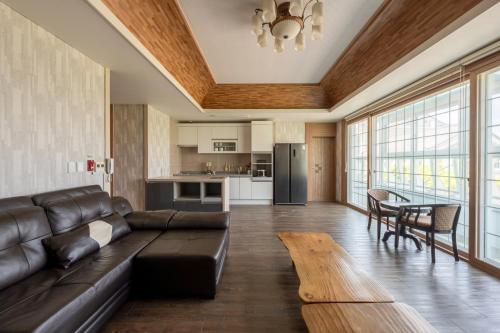 a living room with a leather couch and a table at Gyeongju Hotel Check-in Bulguk in Gyeongju