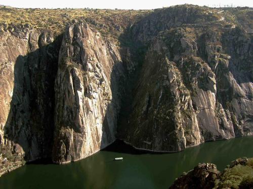 a boat in the middle of a mountain lake at Hotel rural Rinconada de las Arribes in Aldeadávila de la Ribera
