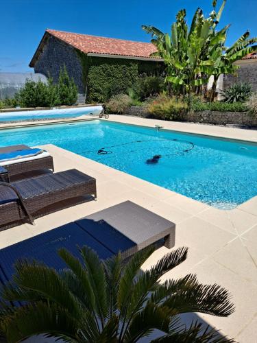 une piscine avec deux chaises et une maison dans l'établissement Chambre à la campagne, à Bécheresse