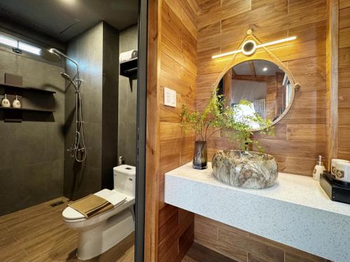 a bathroom with a sink and a mirror and a toilet at Vanilla Ho Tram Homestay in Ho Tram