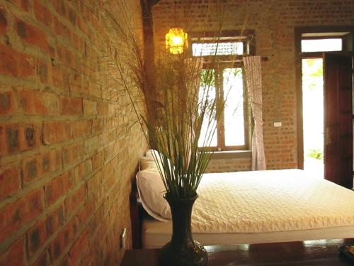 a bedroom with a bed with a brick wall at Ninh Binh Nature Homestay in Ninh Binh
