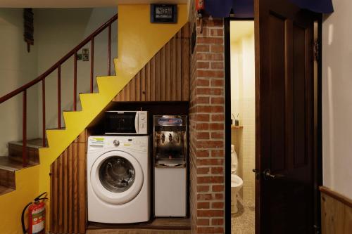 a washing machine in a hallway with a staircase at 赤樓古巷民宿 6-12人可包棟 in Tainan