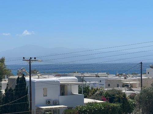 a view of a white house with mountains in the background at CAELI PAROS by Kostas & Joanna Studios in Logaras