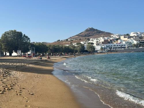 a beach with a group of people and the ocean at CAELI PAROS by Kostas & Joanna Studios in Logaras