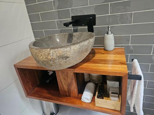 a bathroom with a stone sink on a wooden table at Tuckers Lane Boutique Accommodation in Rothbury