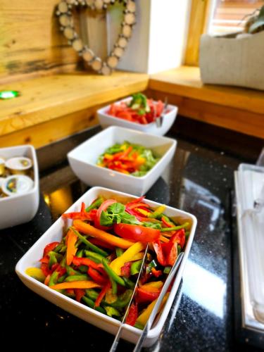 three bowls of vegetables sitting on a table at Aktivhotel Tuxerhof in Zell am Ziller