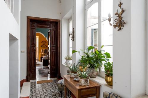 a hallway with potted plants and a wooden table at Dimora Donna Maria in Martina Franca