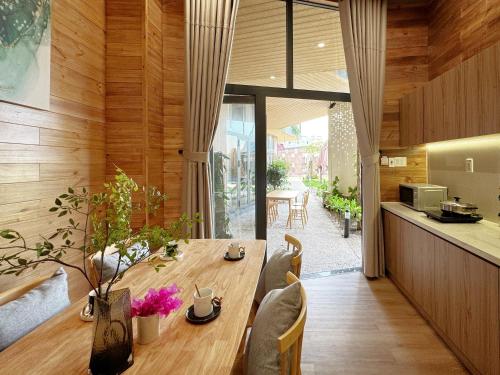 a kitchen and dining room with a wooden table at Vanilla Ho Tram Homestay in Ho Tram