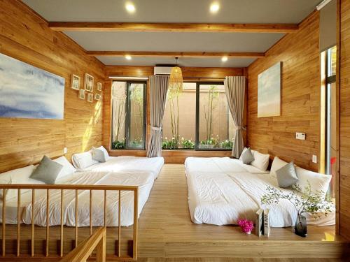 two beds in a room with wooden walls at Vanilla Ho Tram Homestay in Ho Tram