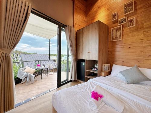 a bedroom with a bed and a balcony with a view at Vanilla Ho Tram Homestay in Ho Tram