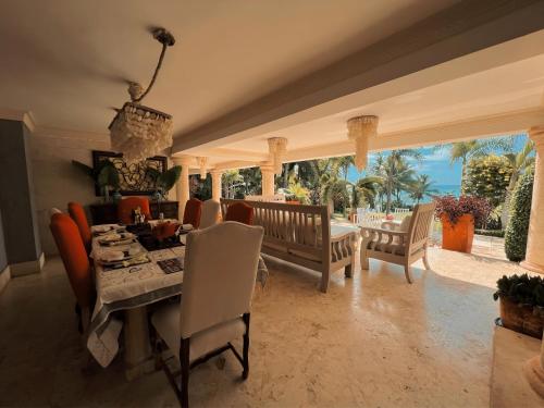 a dining room with a table and chairs and a view at Villa Tesoros del Mar - Luxury Beachfront Villa with Natural Pool, Jacuzzi, Mountain Views, Yoga, BBQ, Wi-Fi, Pet & Family Friendly, Barahona Adventures in El Arroyo