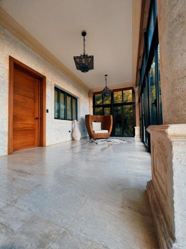 an empty hallway with a wooden door and a chair at Villa Tesoros del Mar - Luxury Beachfront Villa with Natural Pool, Jacuzzi, Mountain Views, Yoga, BBQ, Wi-Fi, Pet & Family Friendly, Barahona Adventures in El Arroyo