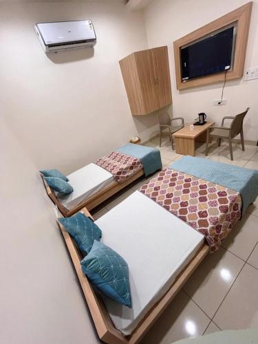 two beds sitting in a room with a tv at Hotel Rajvi Residency A Unit Of Jas Hotels And Resorts in Bikaner