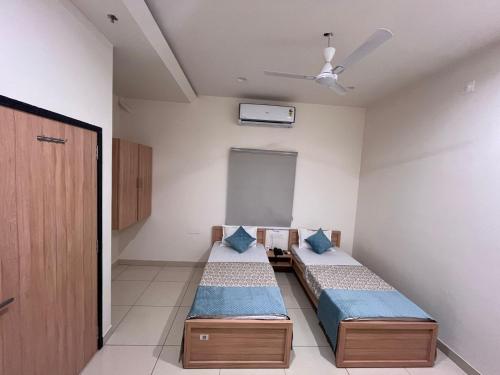a bedroom with two beds and a ceiling fan at Hotel Rajvi Residency A Unit Of Jas Hotels And Resorts in Bikaner
