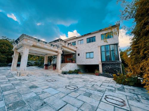 an exterior view of a building with a stone patio at Villa Tesoros del Mar - Luxury Beachfront Villa with Natural Pool, Jacuzzi, Mountain Views, Yoga, BBQ, Wi-Fi, Pet & Family Friendly, Barahona Adventures in El Arroyo