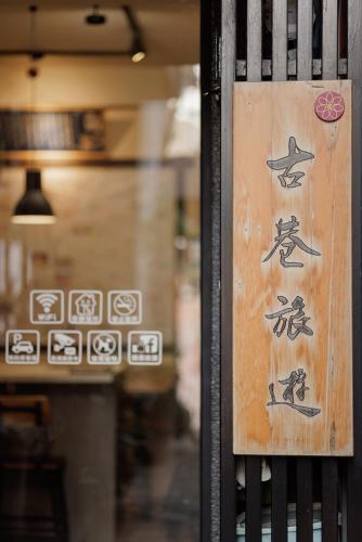 a sign on a door with chinese writing on it at 赤樓古巷民宿 6-12人可包棟 in Tainan