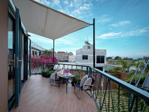 a balcony with two chairs and a table on it at Vanilla Ho Tram Homestay in Ho Tram